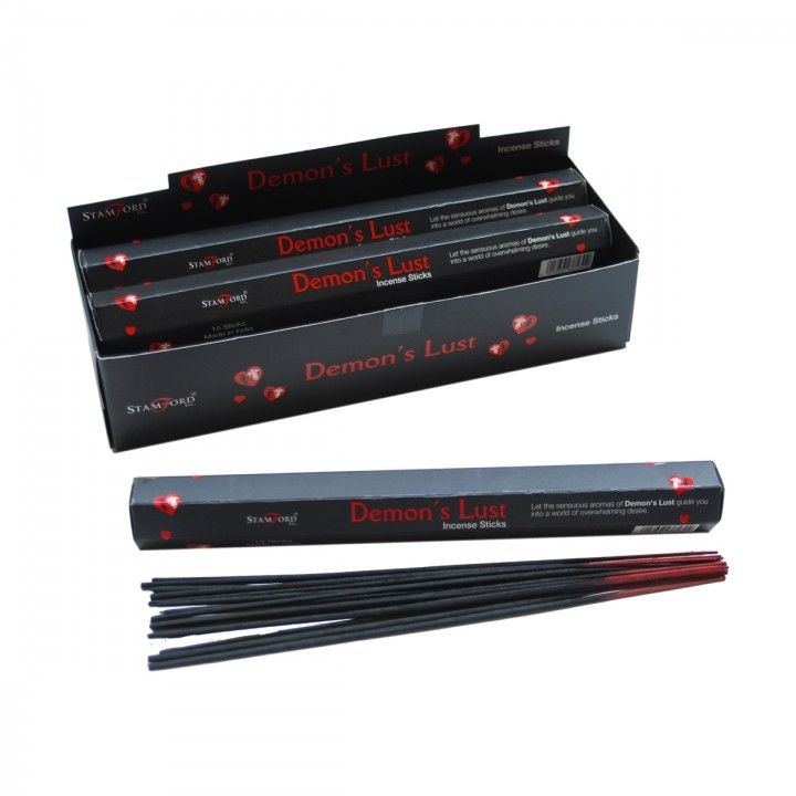 Pack of black incense sticks with mysterious dark themed packaging on a neutral background.