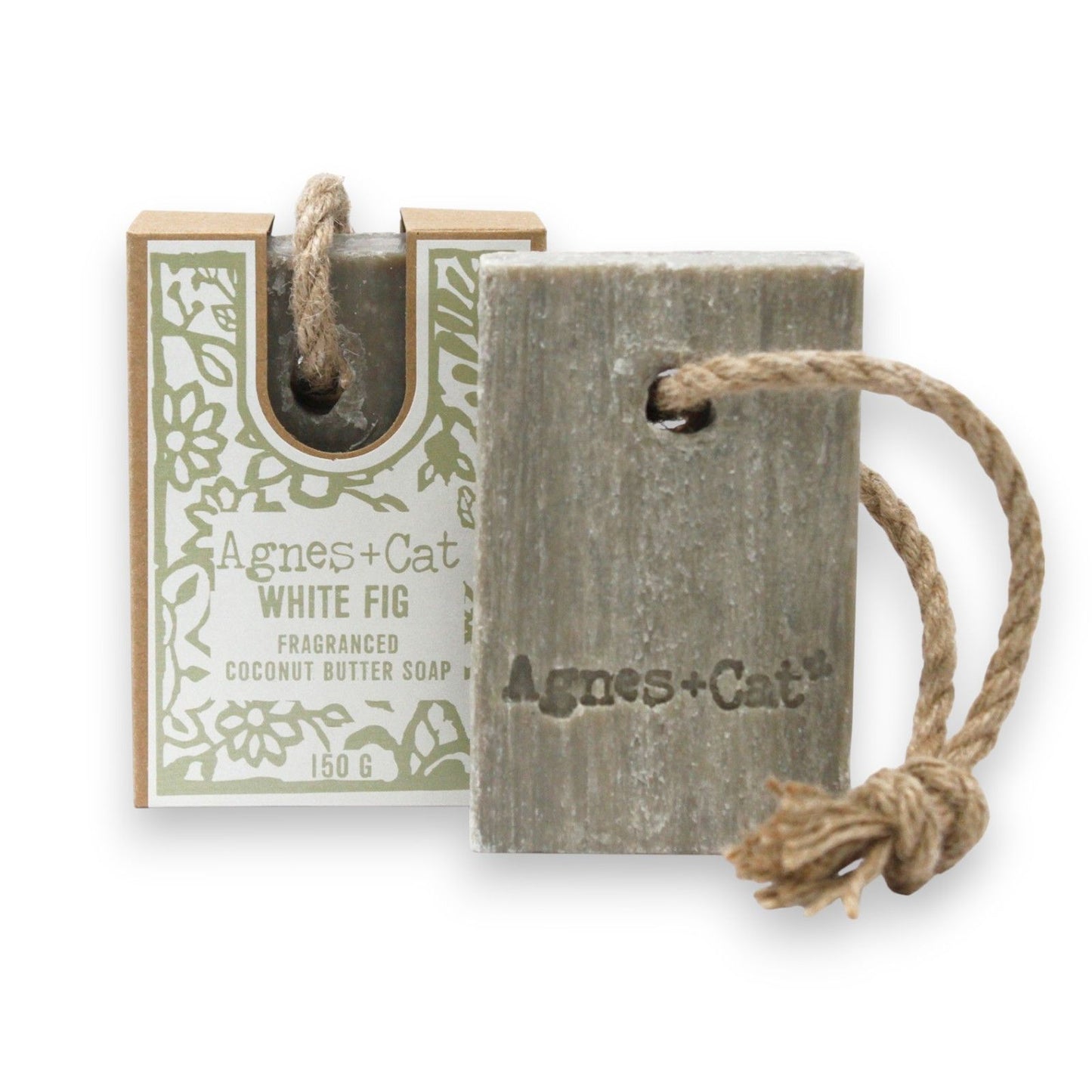 Handmade white fig soap on a natural rope hanging against a minimalist bathroom background.