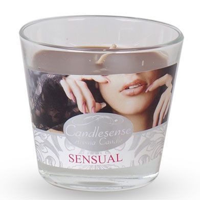 Warm amber scented candle in a clear glass jar with a minimalist label on a wooden surface.