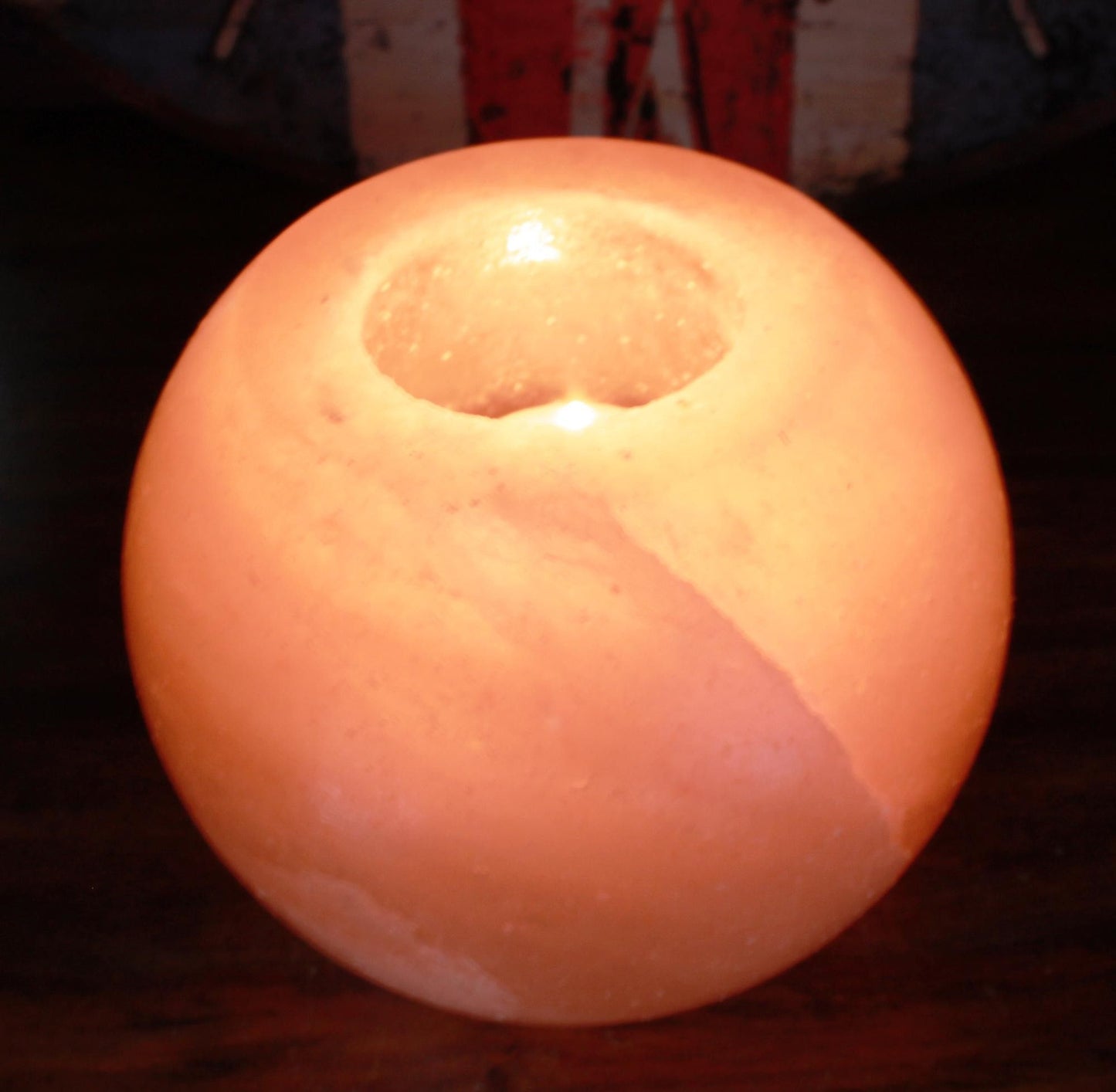 Hand-crafted round pink Himalayan salt candle holder with a natural textured finish and a warm ambient glow.