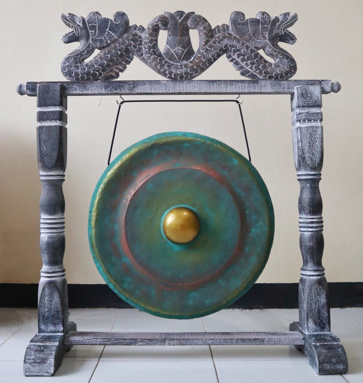 Small 25cm greenwash healing gong hanging from an intricately carved dark wooden stand.