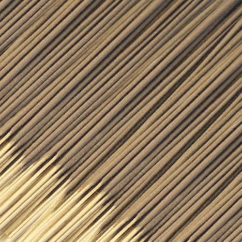 Large bundle of uniform, uncoloured raw incense sticks on a neutral background.