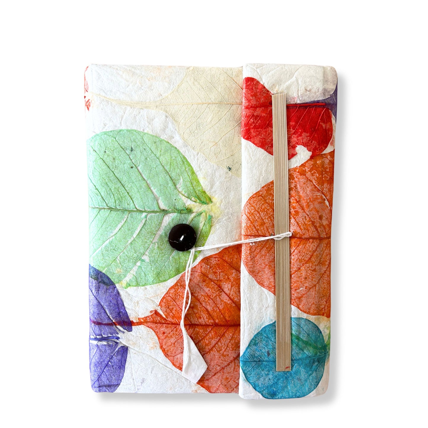 Large handmade notebook with a vibrant cover featuring layered colourful leaf designs on textured Lokta paper.