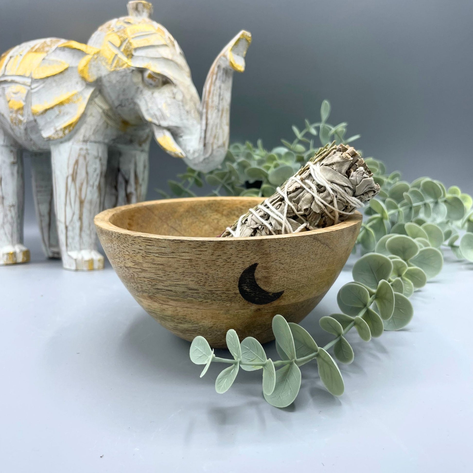 Round wooden ritual bowl with a carved Three Moons design and natural grain finish.