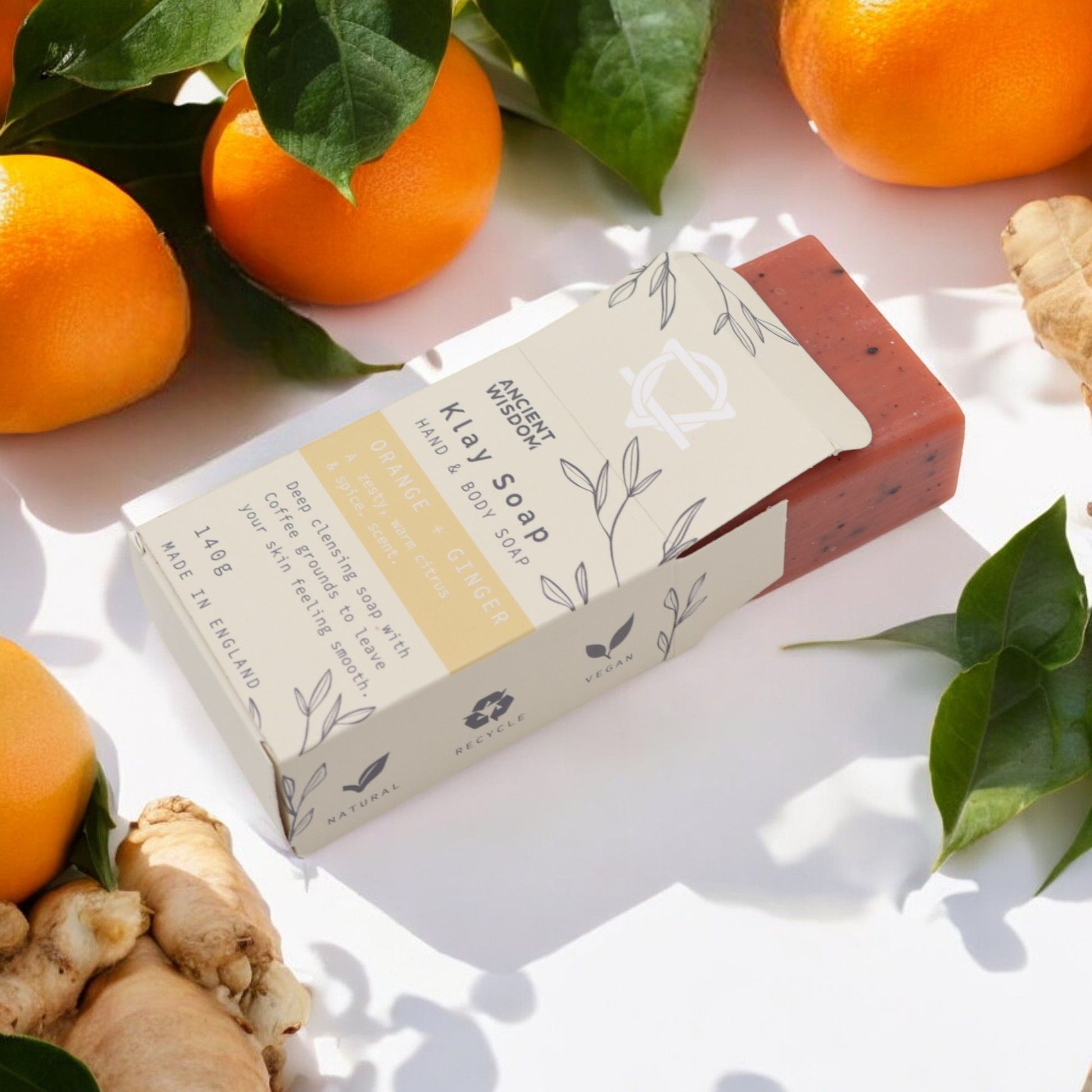 Handmade textured soap bar with orange and ginger, featuring natural clay and exfoliating coffee grounds.