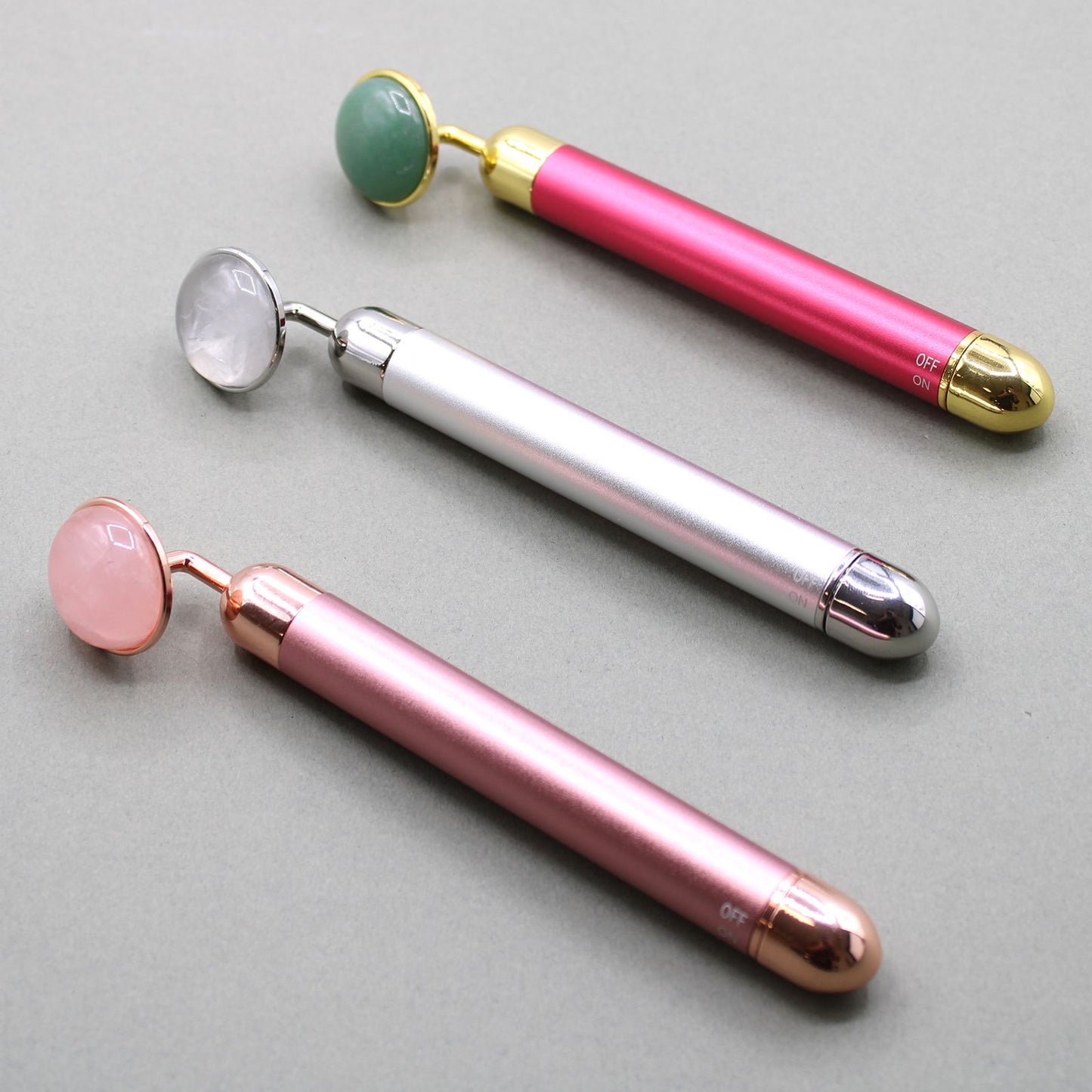 Sleek rock quartz gemstone vibration pad for facial massage, featuring a polished crystal surface and metallic handle.