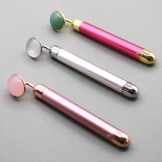 Sleek rock quartz gemstone vibration pad for facial massage, featuring a polished crystal surface and metallic handle.