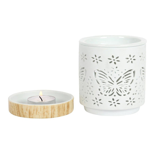 Elegant white matte ceramic oil burner featuring a delicate cutout butterfly design and a deep bowl for wax or oils.