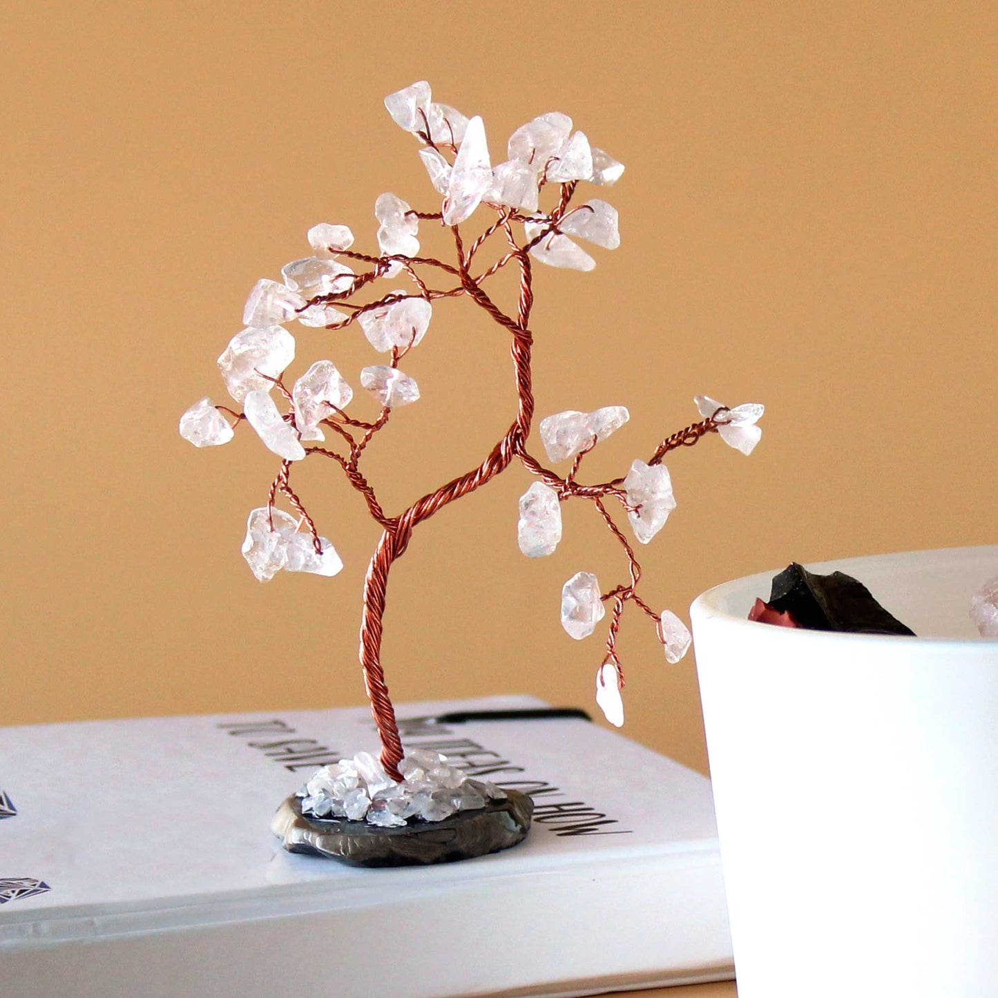 Handcrafted gemstone tree featuring clear rock quartz crystal leaves on a polished black agate base.