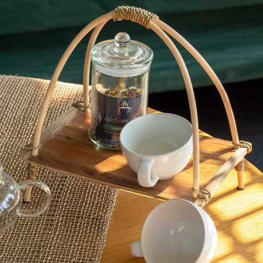 Sustainable handcrafted coconut leaf tea stand with natural wood grain finish and whitewashed rattan decorative details.