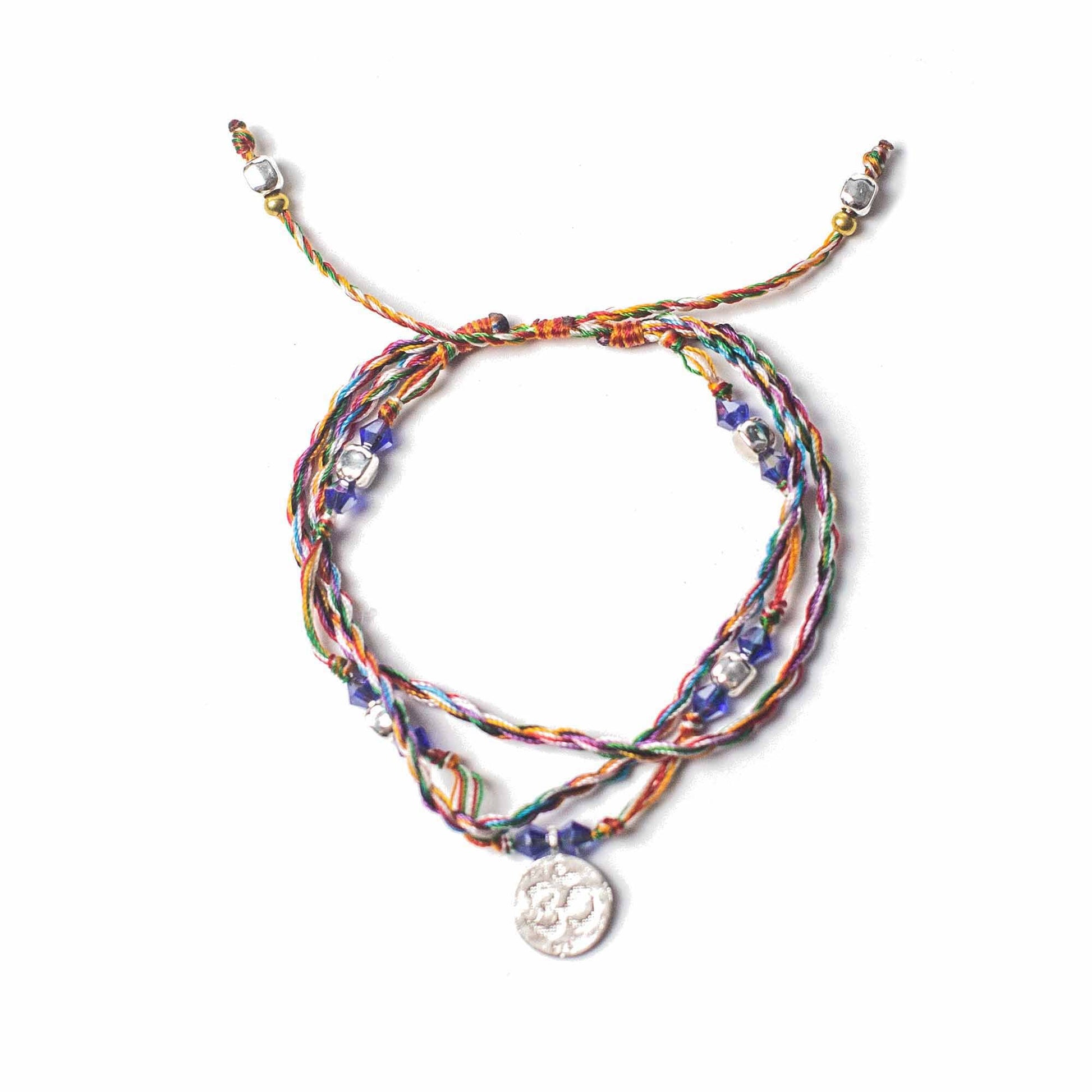 Handcrafted red string bracelet featuring a silver-tone Om symbol charm for spiritual connection and mindfulness.
