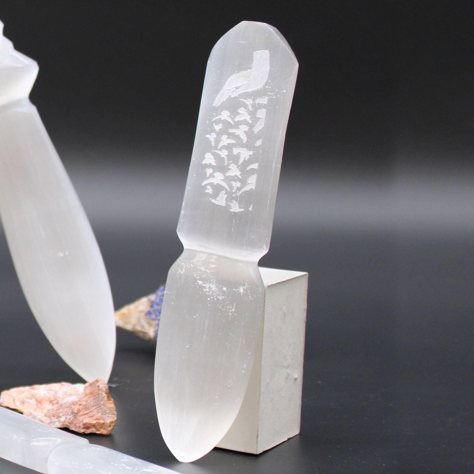 Elegant hand-carved white selenite ritual knife with a pointed blade and decorative handle for spiritual ceremonies.