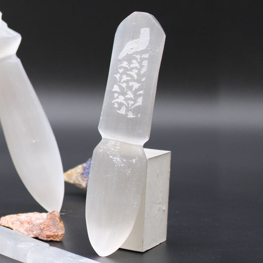 Elegant hand-carved white selenite ritual knife with a pointed blade and decorative handle for spiritual ceremonies.