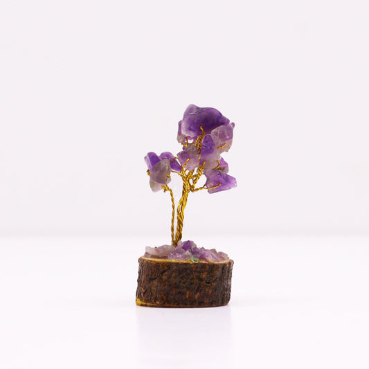 A small decorative tree made with purple amethyst gemstone chips on wire branches, mounted on a natural wood base.