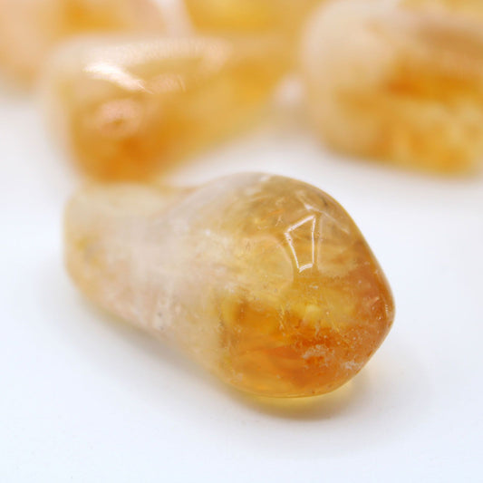 Smooth, bright yellow polished Citrine tumble stone from Brazil showcasing natural crystalline beauty.