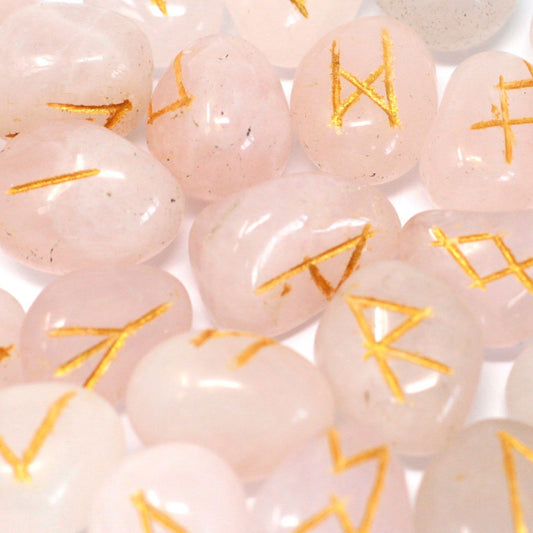 Polished rose quartz rune stones with engraved symbols and a soft drawstring carrying pouch.