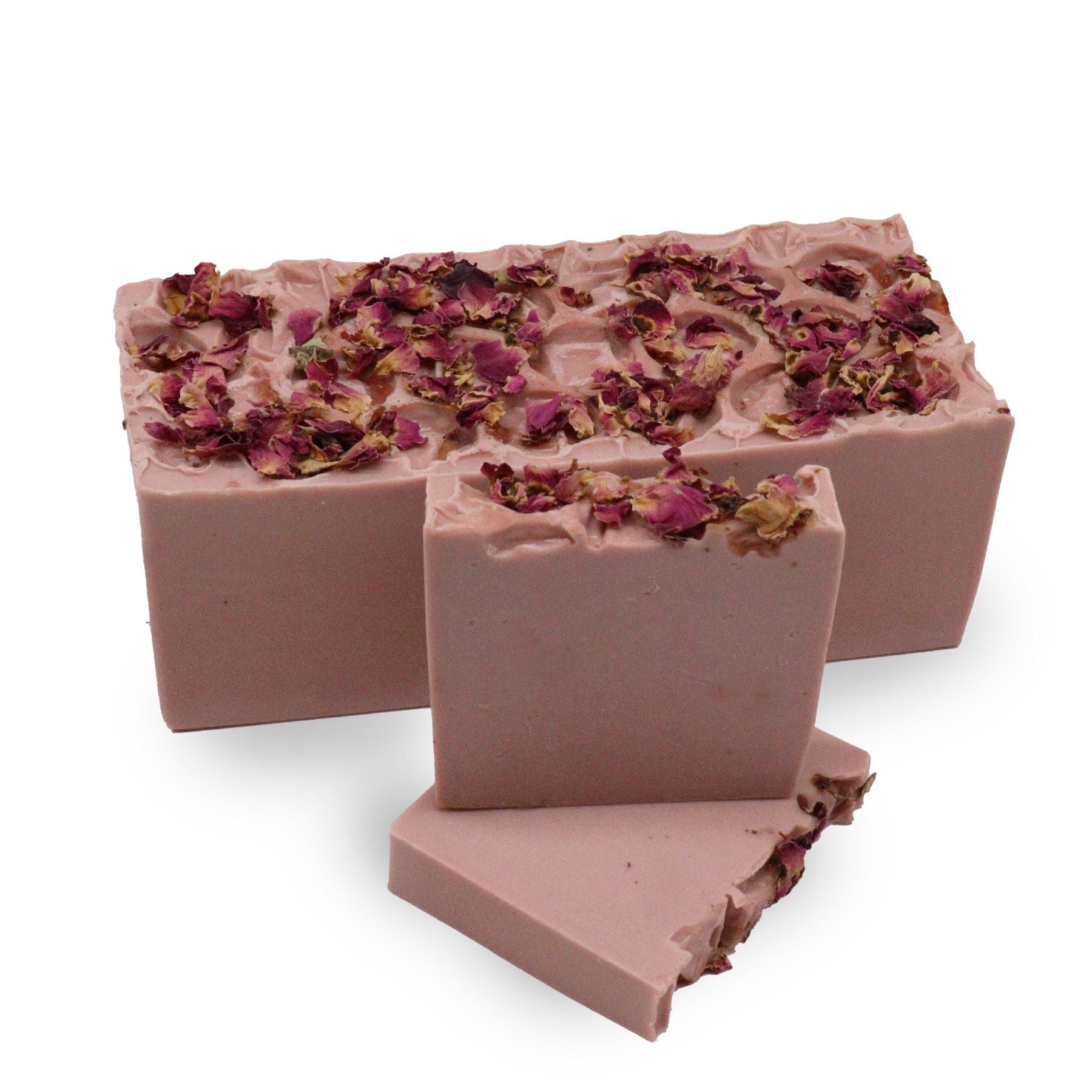A large hand-crafted soap loaf with marbled pink and cream swirls, topped with delicate dried rose petals.