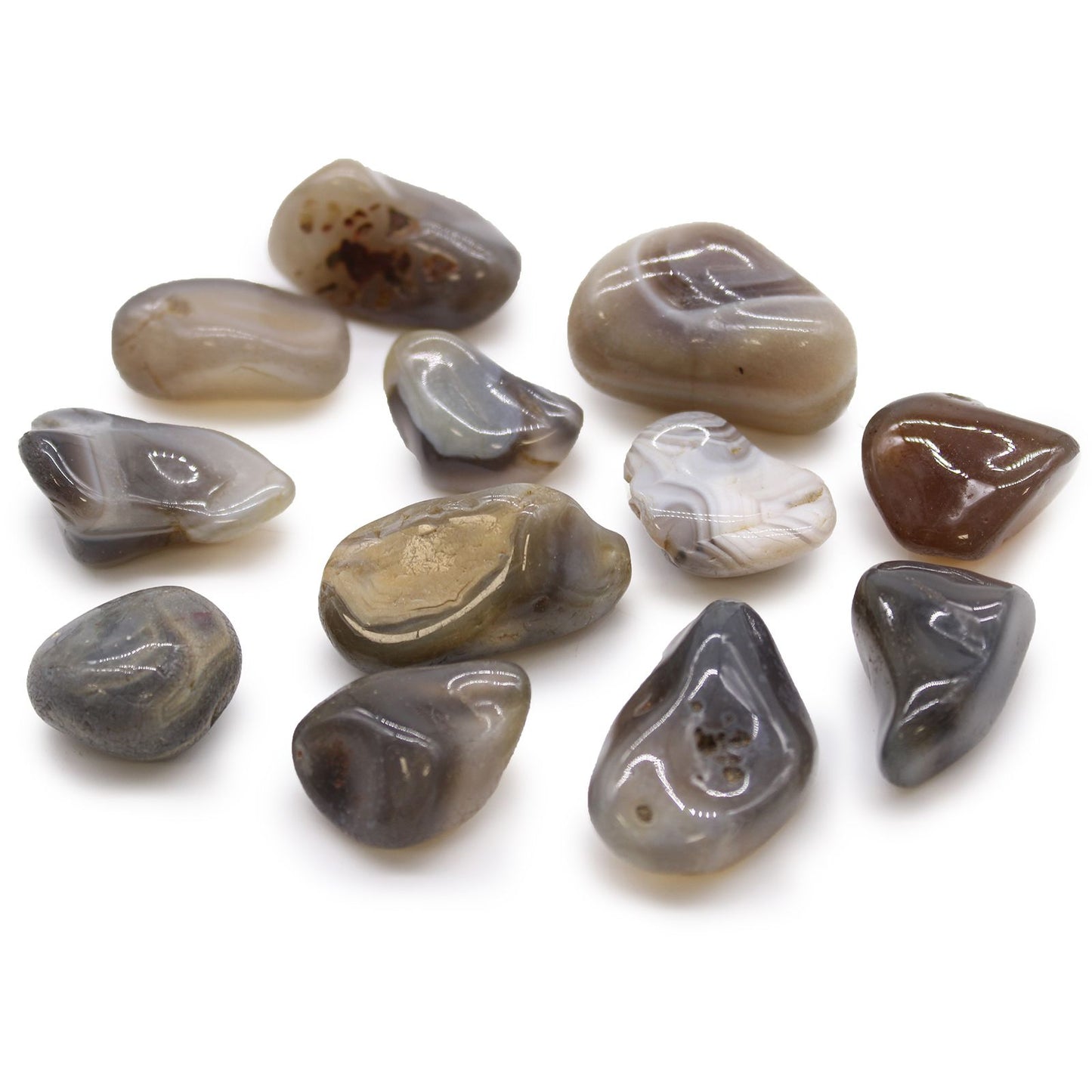 Polished medium-sized grey Botswana agate tumble stones showing natural banded patterns in shades of grey and white.