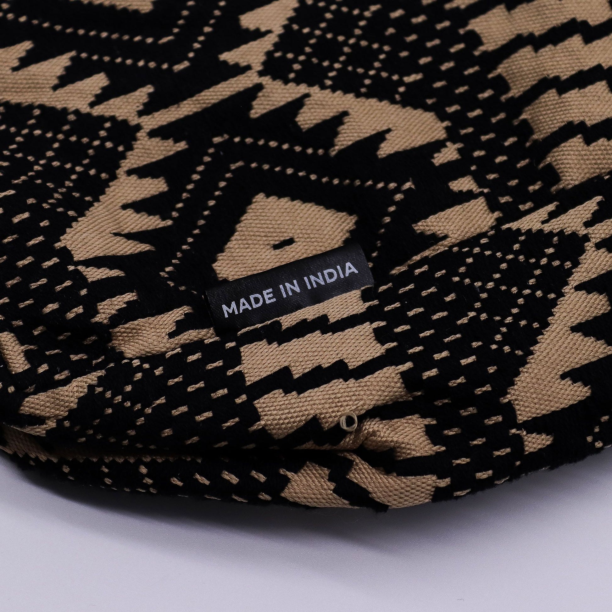 Square jacquard fabric tote bag with an earthy geometric pattern and woven shoulder straps.