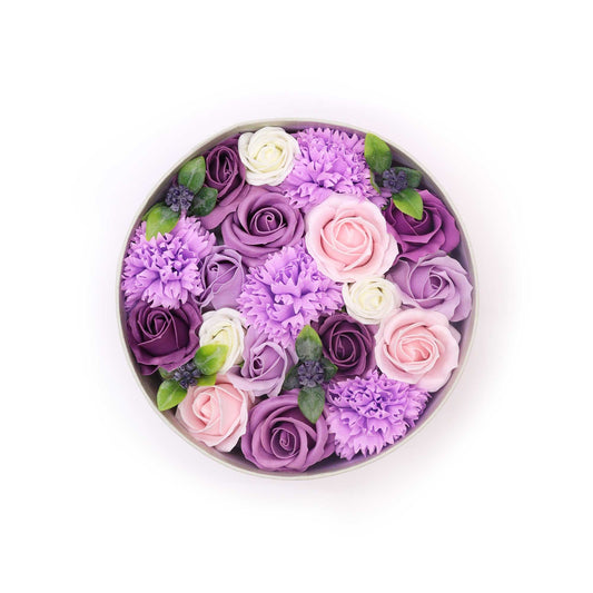 Luxurious round gift box filled with realistic purple soap roses and lavender carnations.
