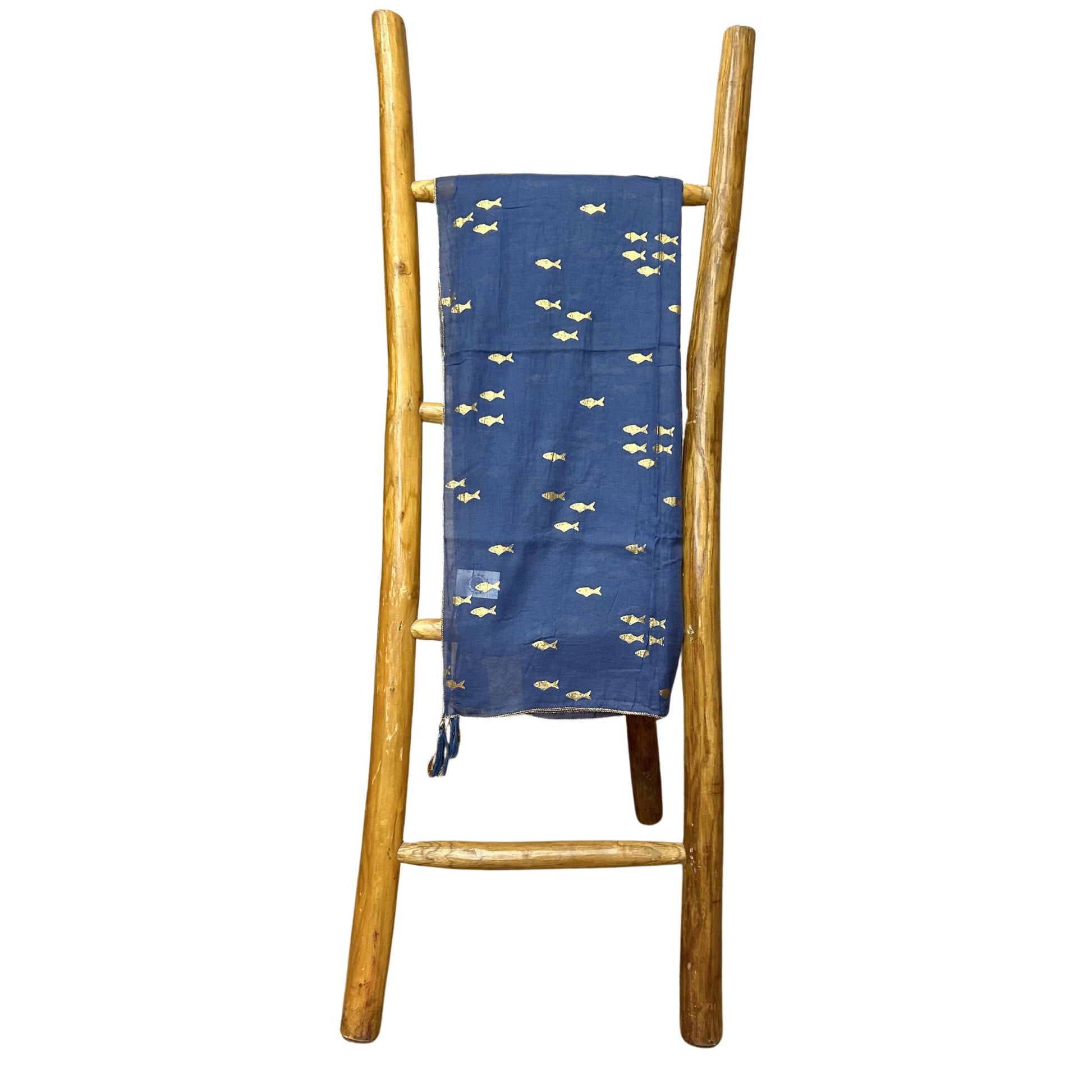Lightweight sea blue pareo featuring an elegant gold fish pattern, draped as a beach cover-up.