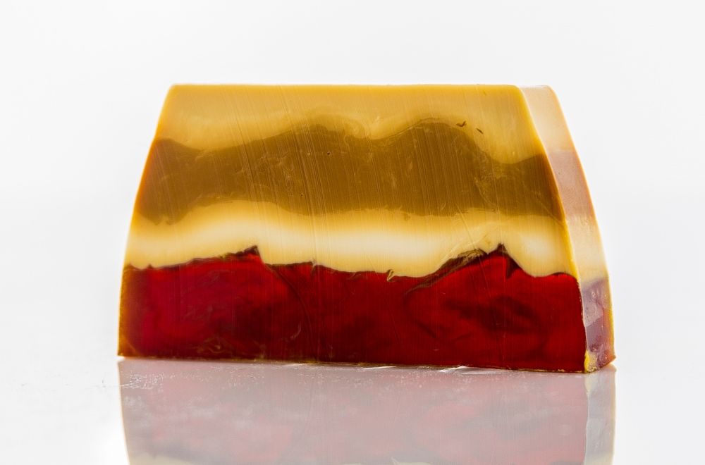 Textured handmade soap slice with a creamy tan colour and decorative topping resembling a sweet cookie treat.