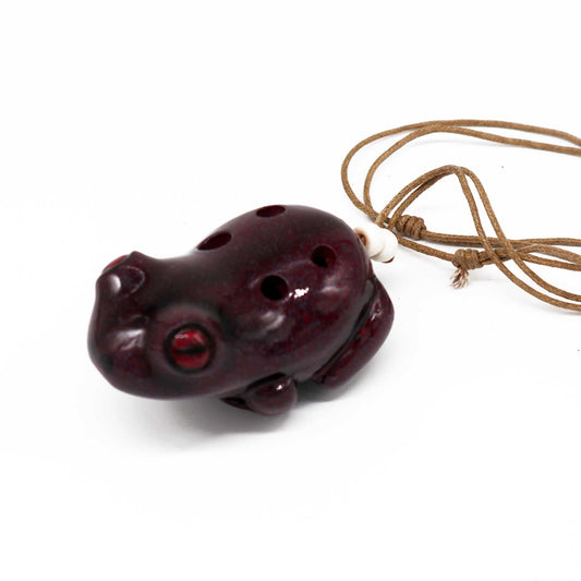 Handcrafted green ceramic ocarina shaped like a whimsical frog with decorative details.
