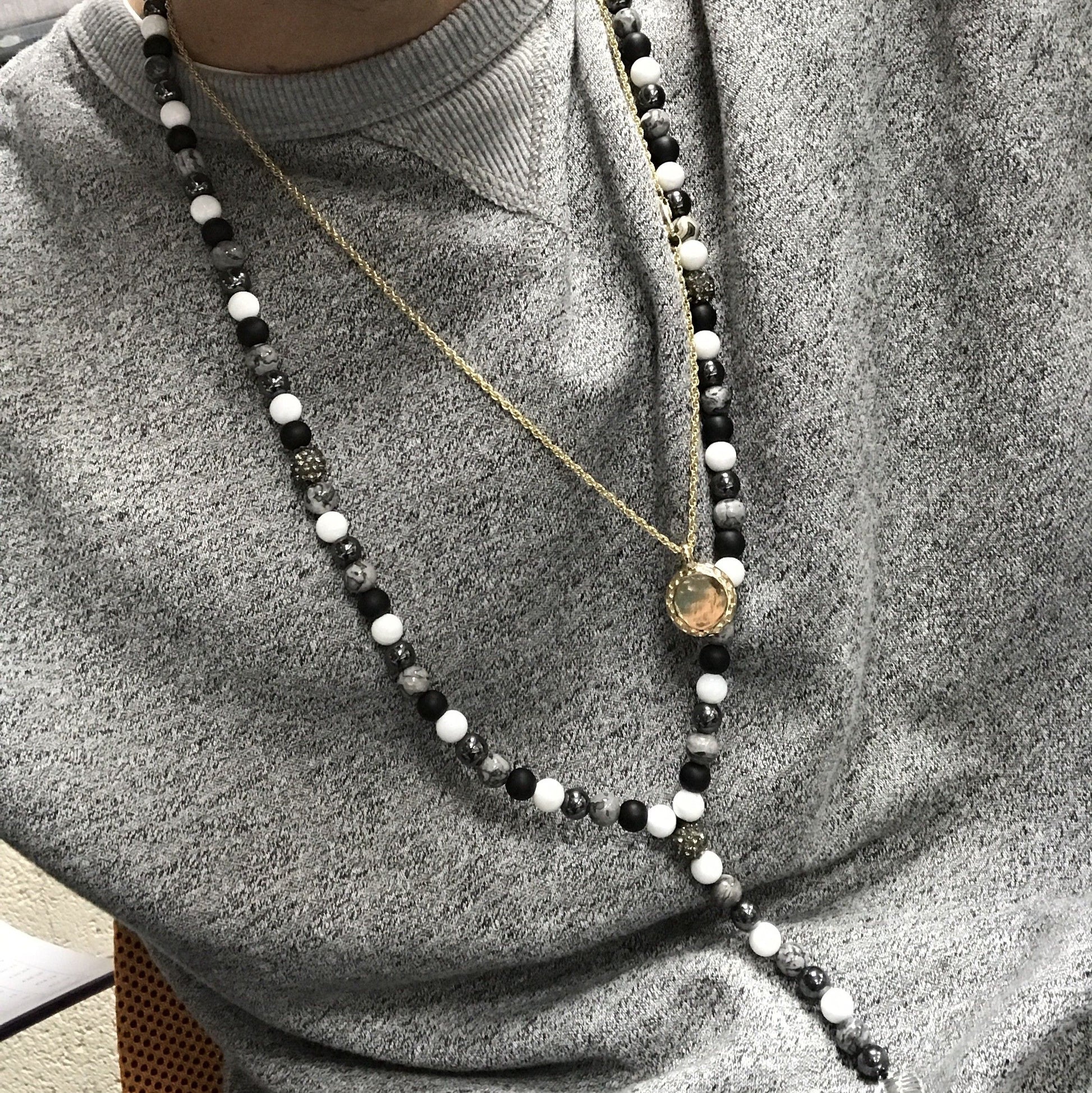 Zen-inspired necklace featuring a Buddha charm and smooth black stone gemstone beads.