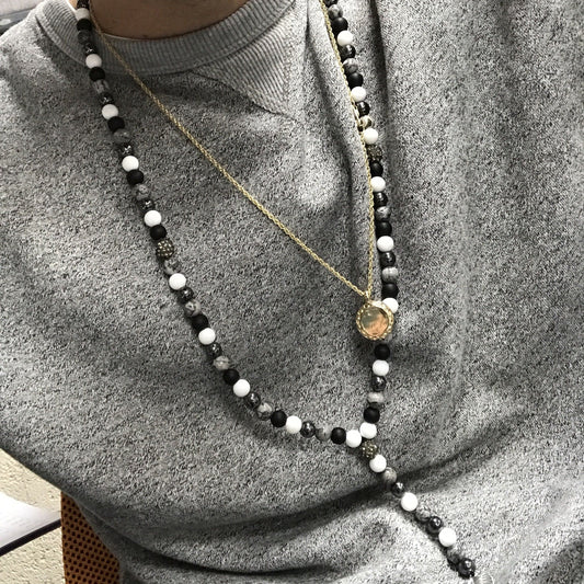 Zen-inspired necklace featuring a Buddha charm and smooth black stone gemstone beads.