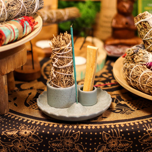 Round matte blue ceramic holder with a central lotus flower design for holding smudge sticks and incense.