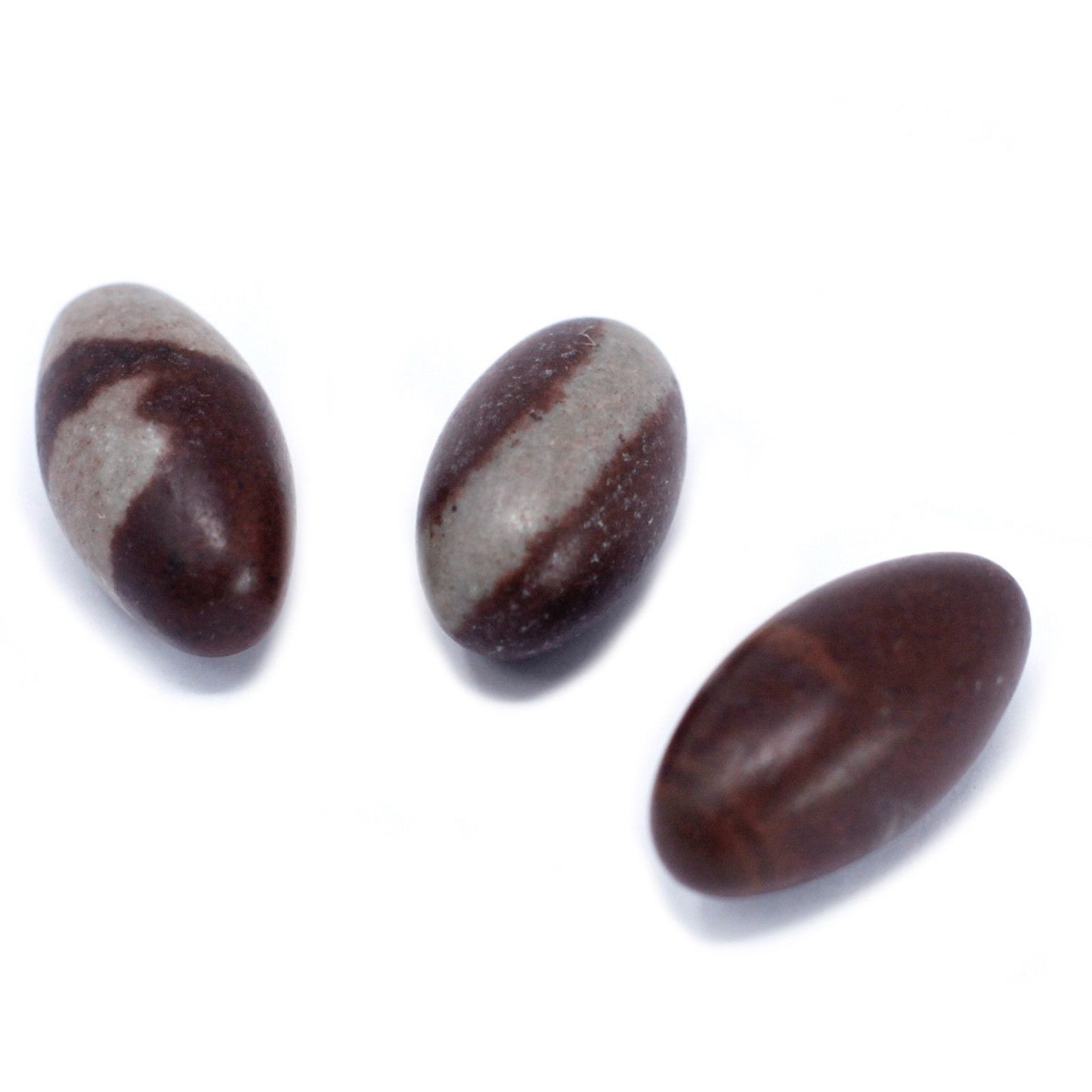 Three small, smooth egg-shaped Shiva Lingam stones with natural brown and tan markings.