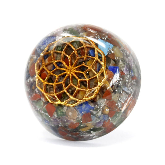 Dome-shaped orgonite paperweight featuring a mix of colourful gemstone chips, copper coils, and metal filings.