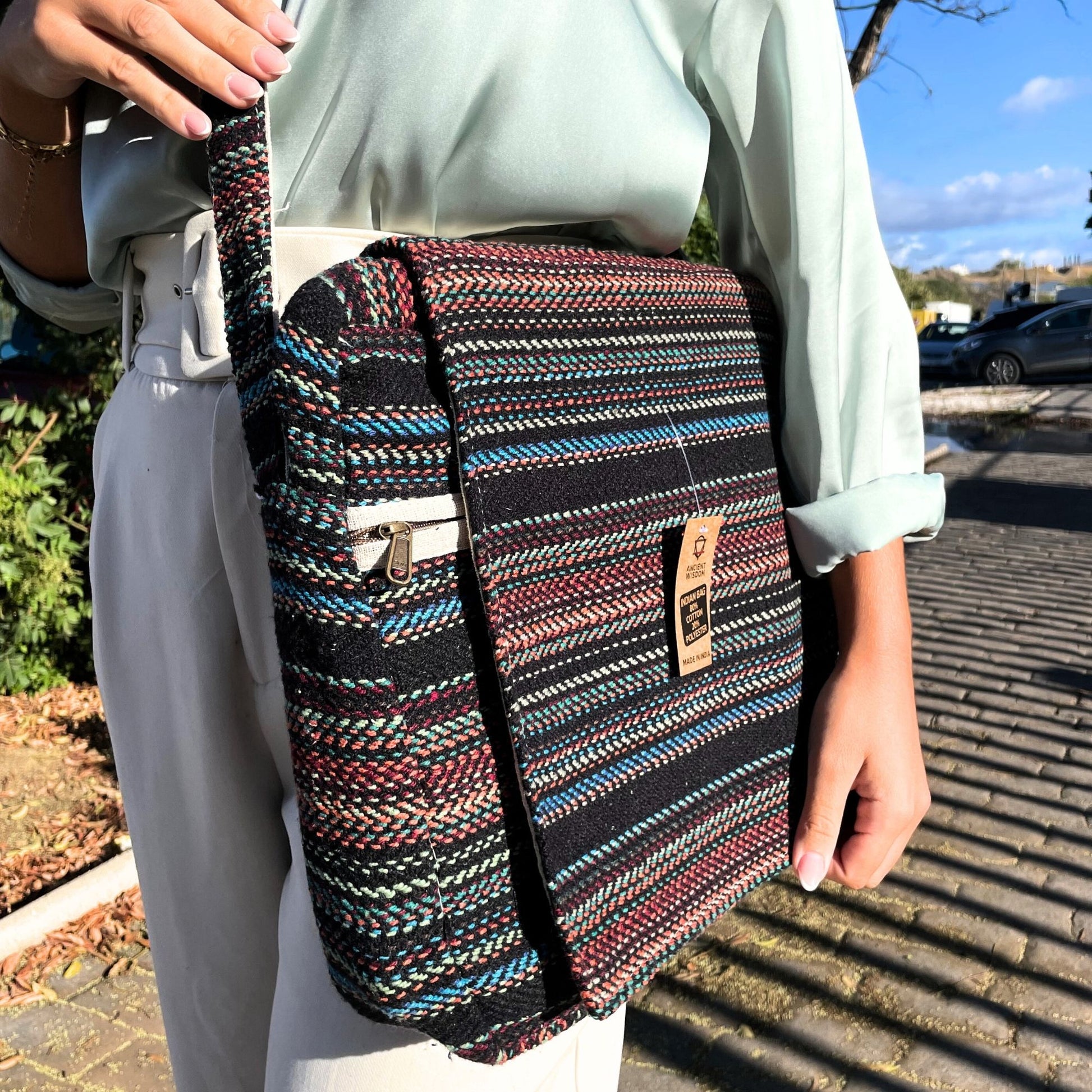 Close up of a dark patterned soft laptop bag with intricate traditional weaving and a slim protective design.