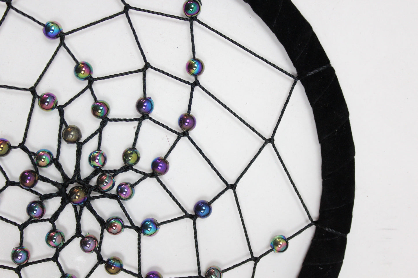 Large round handmade dreamcatcher featuring vibrant turquoise, pink, and purple threads with decorative feathers.