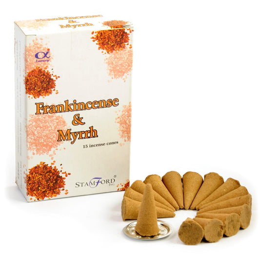A pile of dark brown conical incense pieces releasing a gentle trail of smoke in a serene setting.