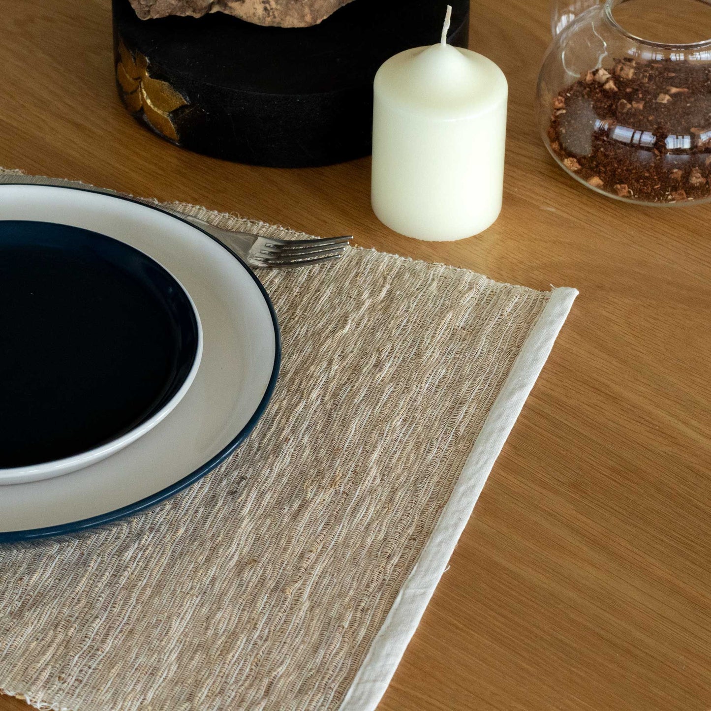 Handcrafted round placemat made from natural woven vetiver roots showing textured organic fibres.