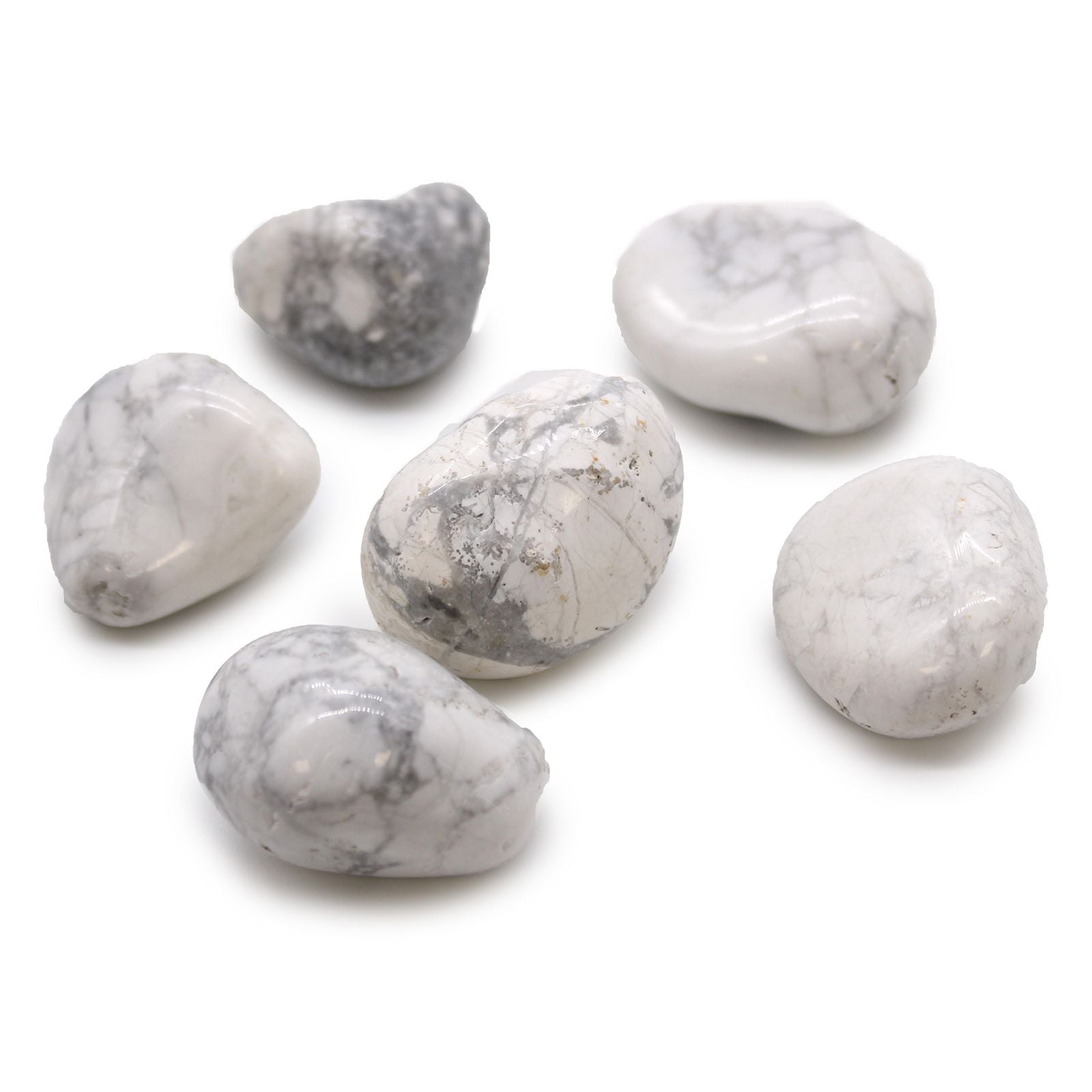 Smooth, large white tumble stones with grey veining, known as Howlite and Magnesite, displayed on a neutral surface.