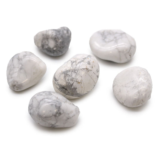 Smooth, large white tumble stones with grey veining, known as Howlite and Magnesite, displayed on a neutral surface.