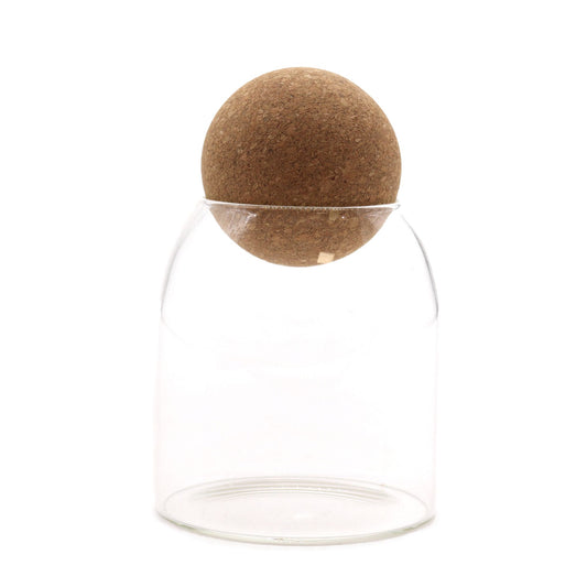 Small clear glass jar with a unique round cork ball lid, shown in a simple cottage style.