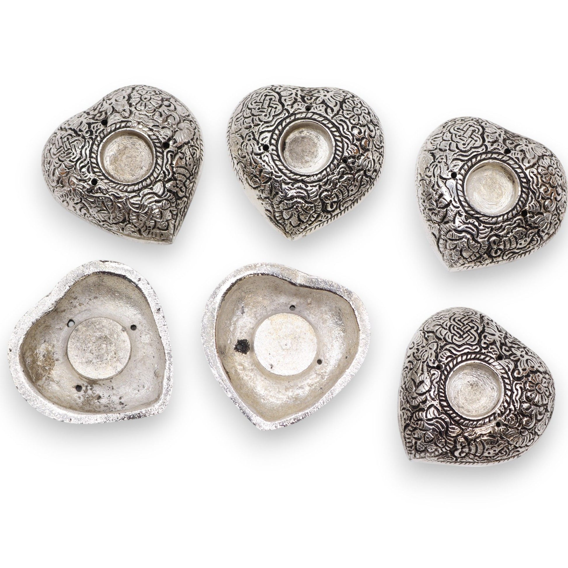 Small silver heart-shaped aluminium incense holder on a neutral background.