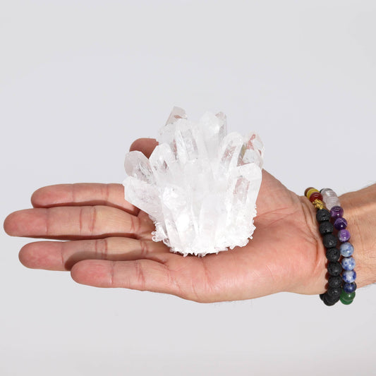 Sparkling clear quartz crystal cluster with natural points and a textured base.