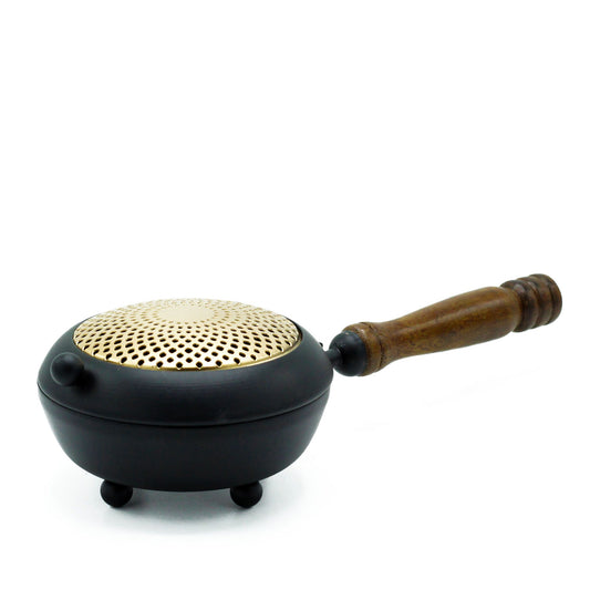 Large black iron censer incense burner with ornate gold-toned metal detailing and a sturdy tripod stand.