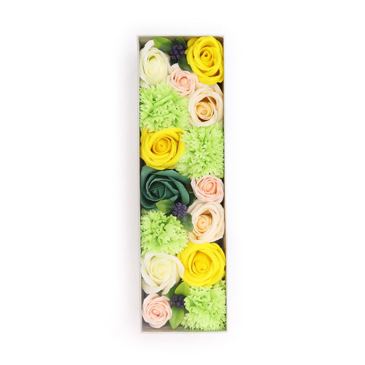 A long gift box filled with realistic soap flowers in bright yellow and fresh green shades.