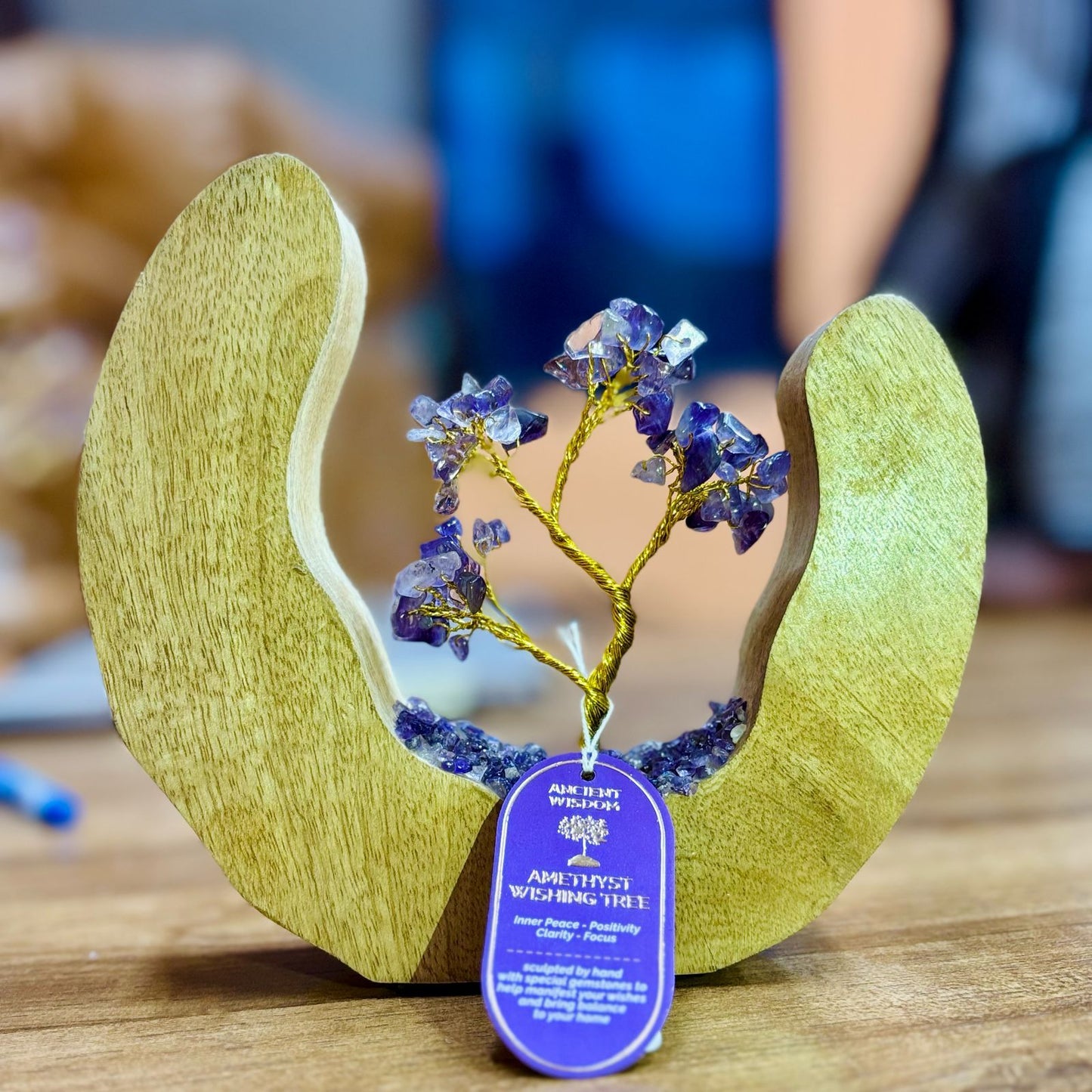 Handcrafted crystal tree featuring purple amethyst chipstones on wire branches inside a circular mango wood ring base.