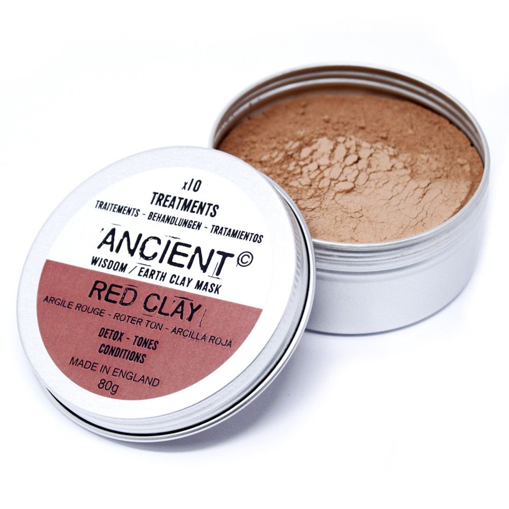 Close-up of fine red kaolin clay powder in a clear glass jar for a natural face mask treatment.