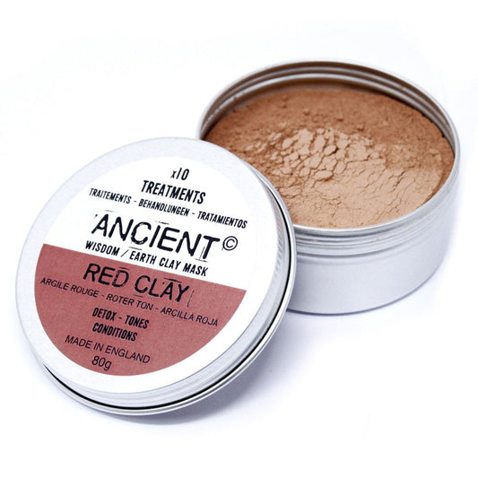 Close-up of fine red kaolin clay powder in a clear glass jar for a natural face mask treatment.