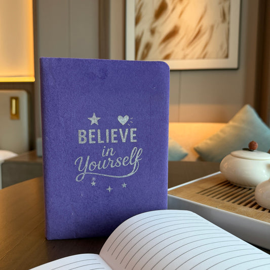 Soft lavender velvet notebook with silver embossed Believe in Yourself text on the front cover.