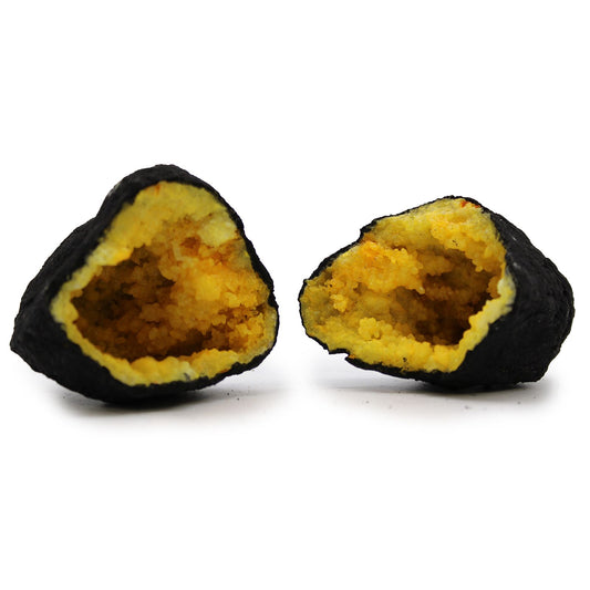A split black rock geode revealing bright yellow calcite crystals in a hollow centre.