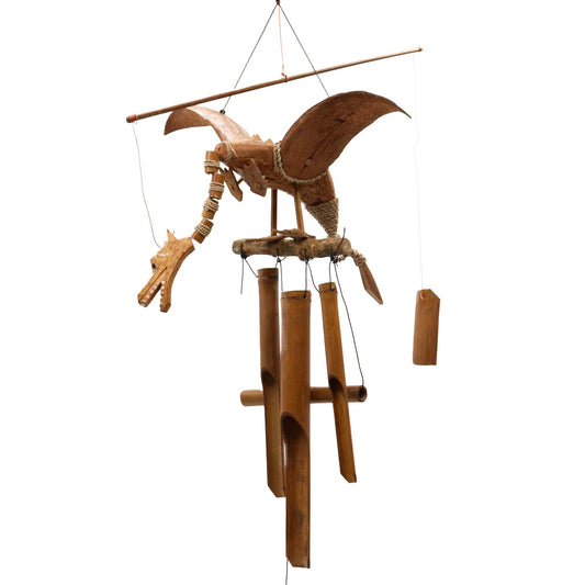 Handcrafted dragon wind chime made from coconut shells with large wings hanging from a hook.