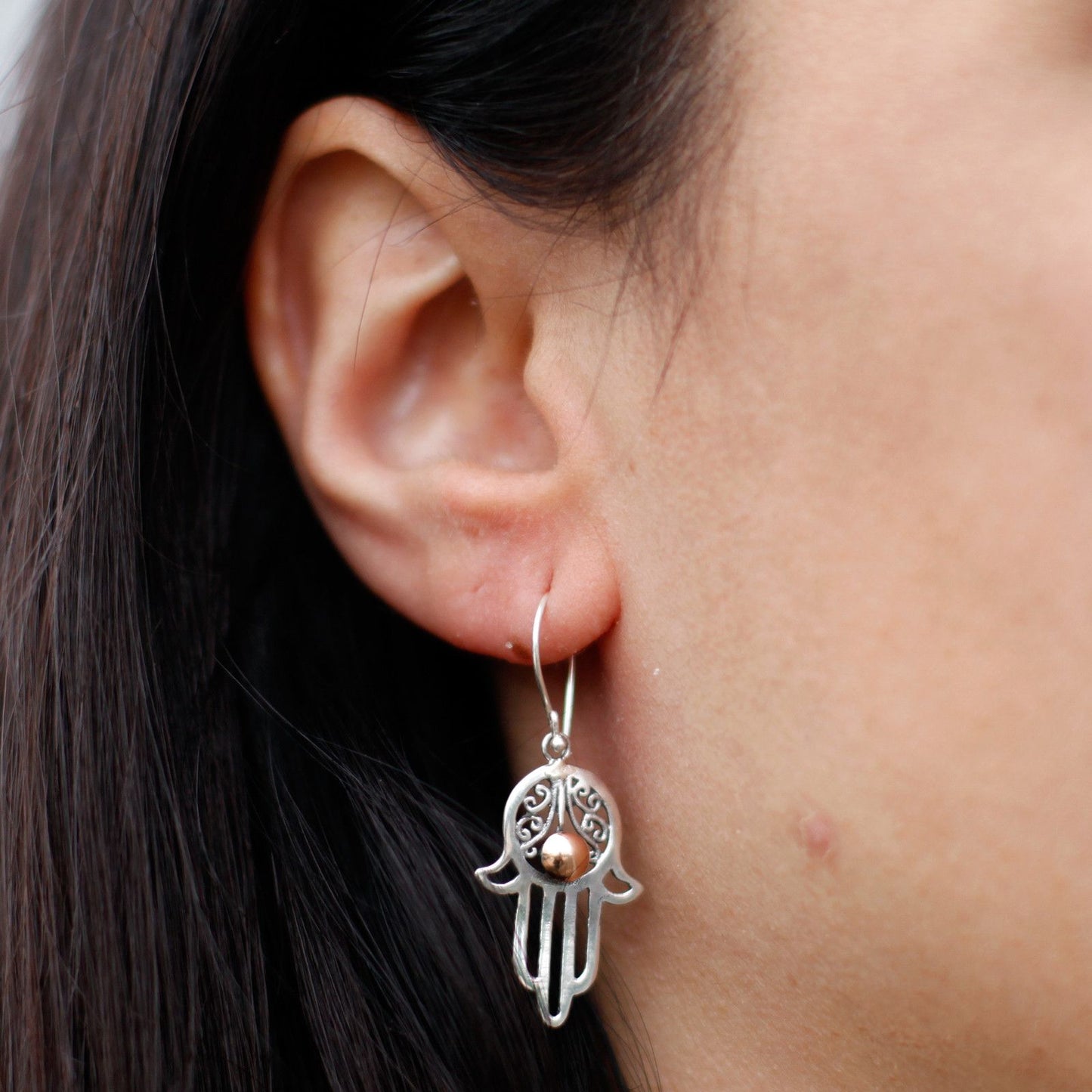 Intricate mixed metal Hamsa hand drop earrings featuring both silver and gold finishes.